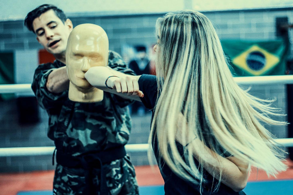 Spinning back elbow in the ring by blonde girl fighter